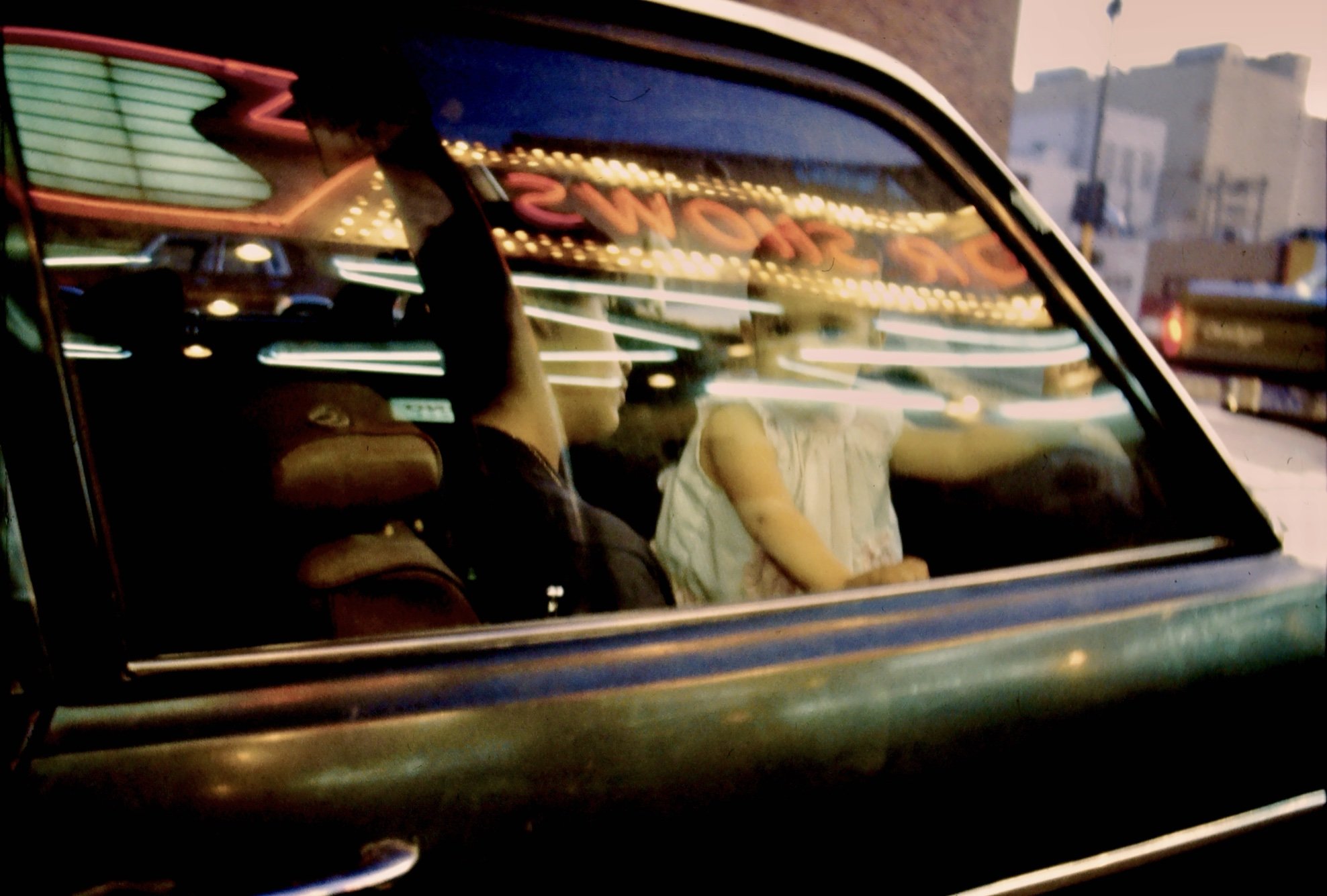 Editorial portrait by G. John Slagle &mdash; figures inside a car beneath the El Cortez marquee, downtown Las Vegas, available light, 35mm color film.